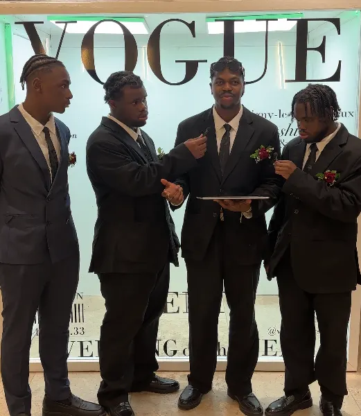 Quatre invités en costume enregistrent leur message pour l'interview des invités devant un décor de magazine