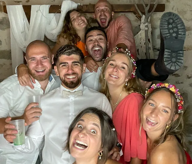 Des invités de mariage hilares se serrent devant l'objectif du photobooth