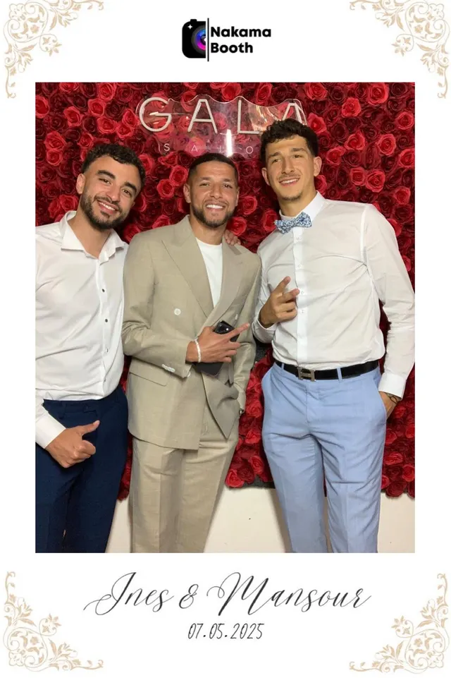 Tirage photobooth 10x15 du mariage d'Ines et Mansour : le footballeur Amine Harit et deux invités en costume posent devant un mur de roses rouges